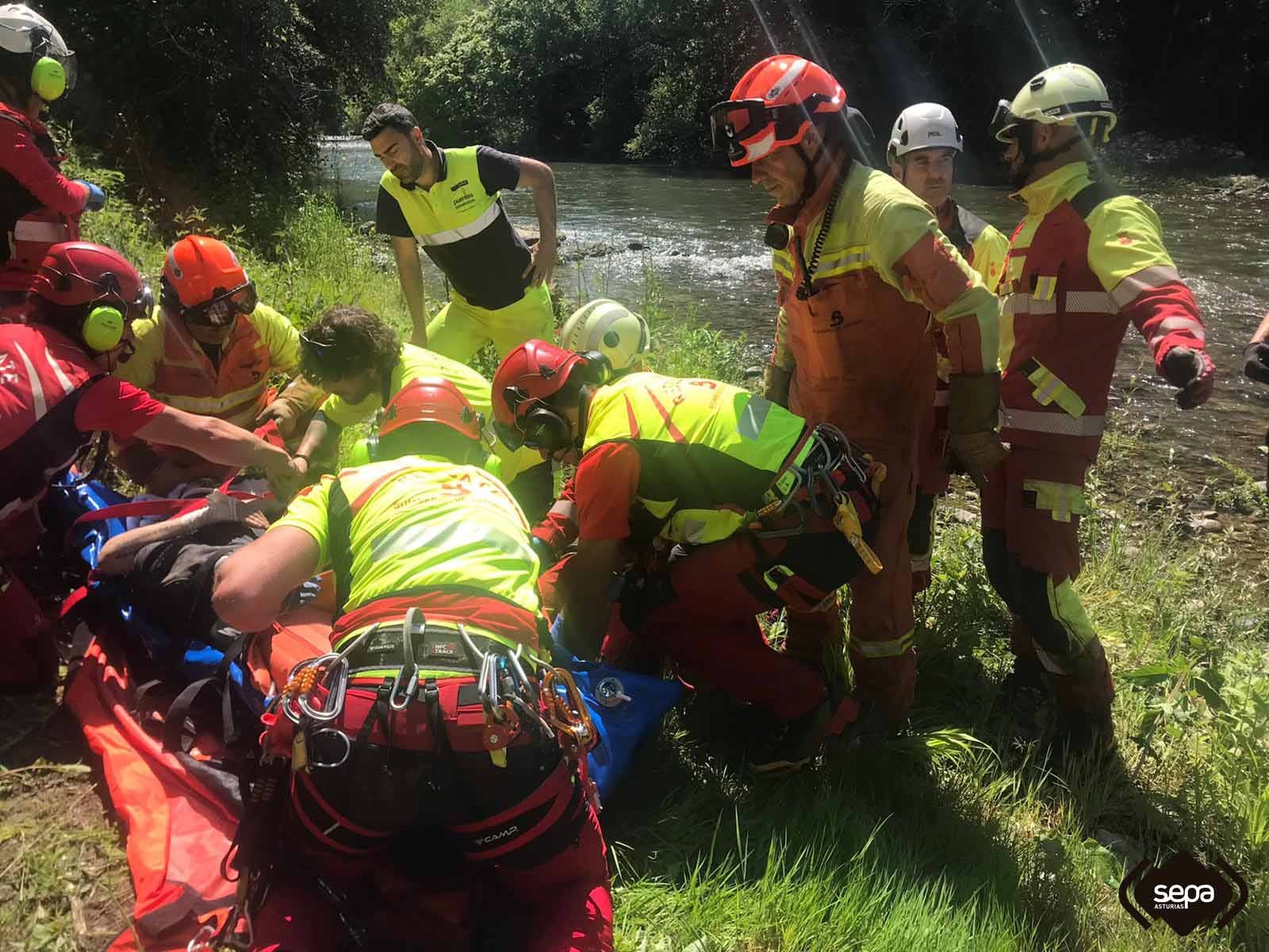 Efectivos de bomberos con el accidentado en Peamellera Baja.